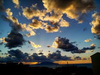 Silhouette of trees against cloudy sky