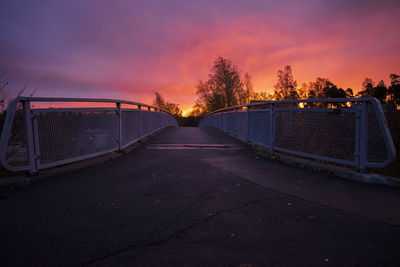 Illuminated bridge against sky at sunset