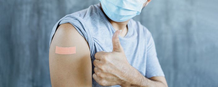 Midsection of man with arms raised standing in background