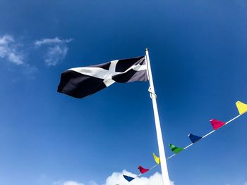 Low angle view of flag against blue sky