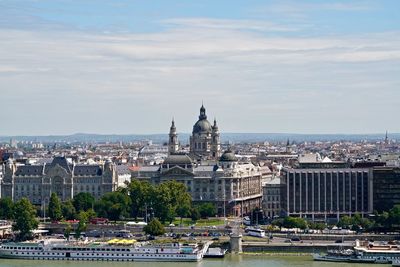 Buildings in city against cloudy sky