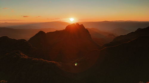 Scenic view of silhouette mountains against sky during sunset