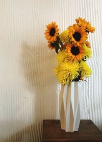 Close-up of yellow flower vase on table