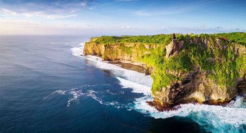 Scenic view of rocks on sea against sky
