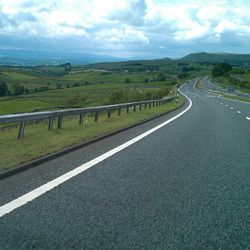 Empty road passing through field