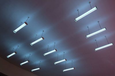 Low angle view of illuminated lighting equipment hanging from ceiling