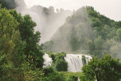 Scenic view of waterfall against sky