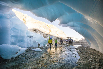 Three adventurers enter a glacial cave.