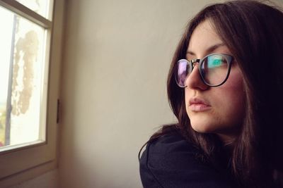 Portrait of woman wearing eyeglasses at home