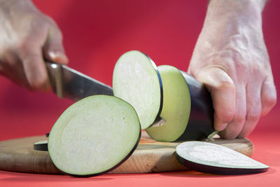 Midsection of person holding fruits on cutting board