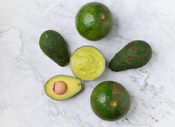 High angle view of green fruits on white surface