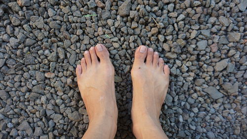 Low section of person standing on stones