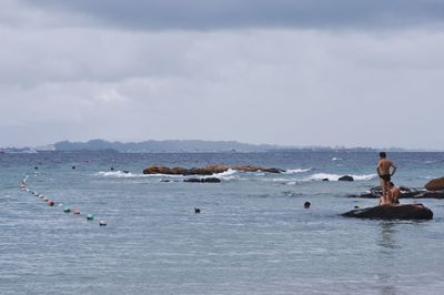 People on sea against sky