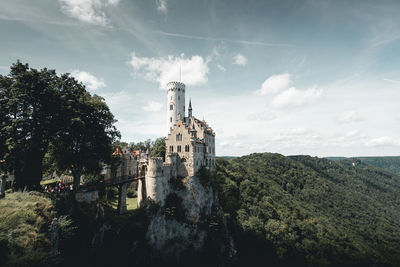 Castle by buildings against sky