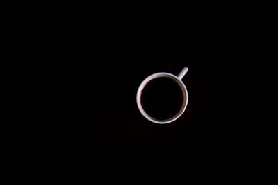 Directly above shot of coffee cup against black background