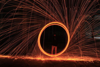 Man spinning wire wool at night