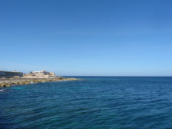 Scenic view of sea against clear blue sky