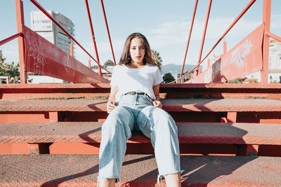 Full length of woman sitting on staircase