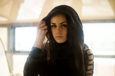 Portrait of beautiful young woman wearing hood