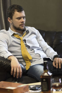 Young man sitting on sofa at home