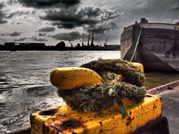 Close-up of yellow moored by sea against sky