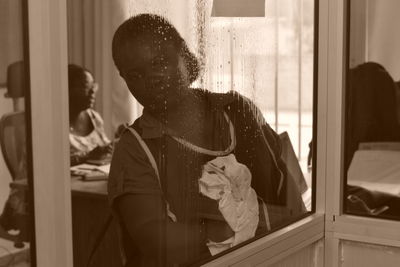 Man looking through window at home