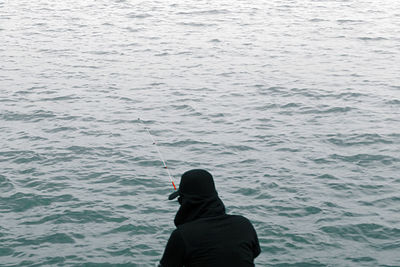 Rear view of man standing in sea