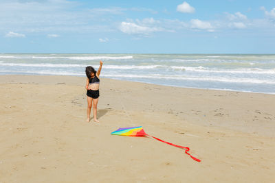 Rear view of woman walking at beach