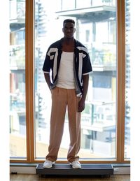 Portrait of young man standing against window