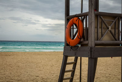 Lifeguard hut on beach against sky