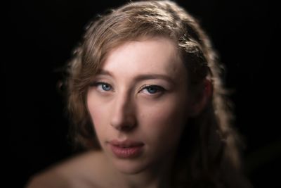 Portrait of woman against black background