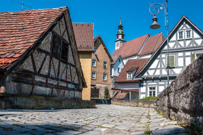 Houses by street against sky in city