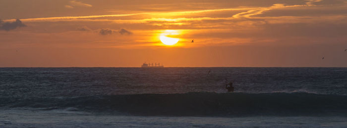 Scenic view of sea against orange sky