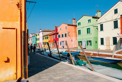 View of canal amidst buildings against clear blue sky