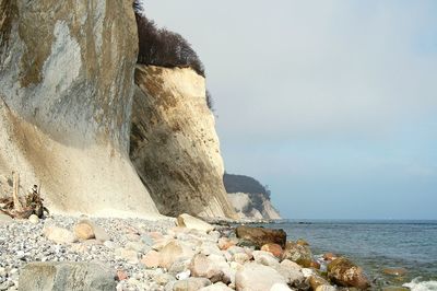 Scenic view of cliffs by sea against sky at jasmund national park