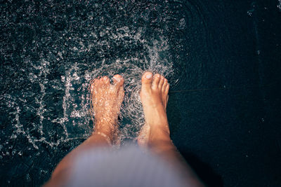 Low section of woman standing in water