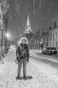 Portrait of young woman with snow in city at night