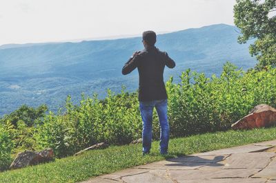 Full length of woman standing on mountain against sky