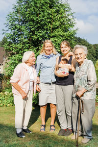 Full length portrait of happy family standing outdoors