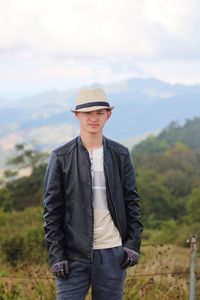 Young man wearing hat standing on land