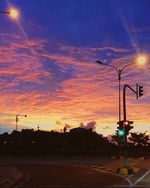 ILLUMINATED STREET LIGHTS AGAINST SKY DURING SUNSET