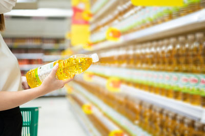 Midsection of person holding ice cream cone at store