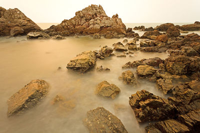 Scenic view of rocks in sea against sky