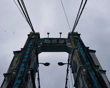 Low angle view of bridge and buildings against sky