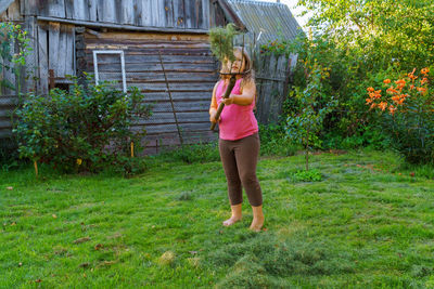 Full length of woman standing in yard