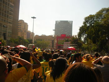 Crowd on city street against sky