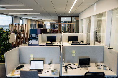 Empty tables with laptops in modern coworking office