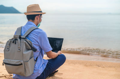 Side view of man standing at beach