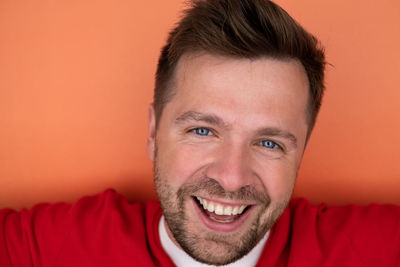 Close-up portrait of young man against yellow background