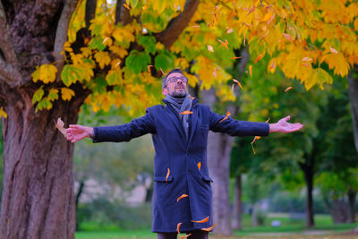 Full length of person standing on tree during autumn